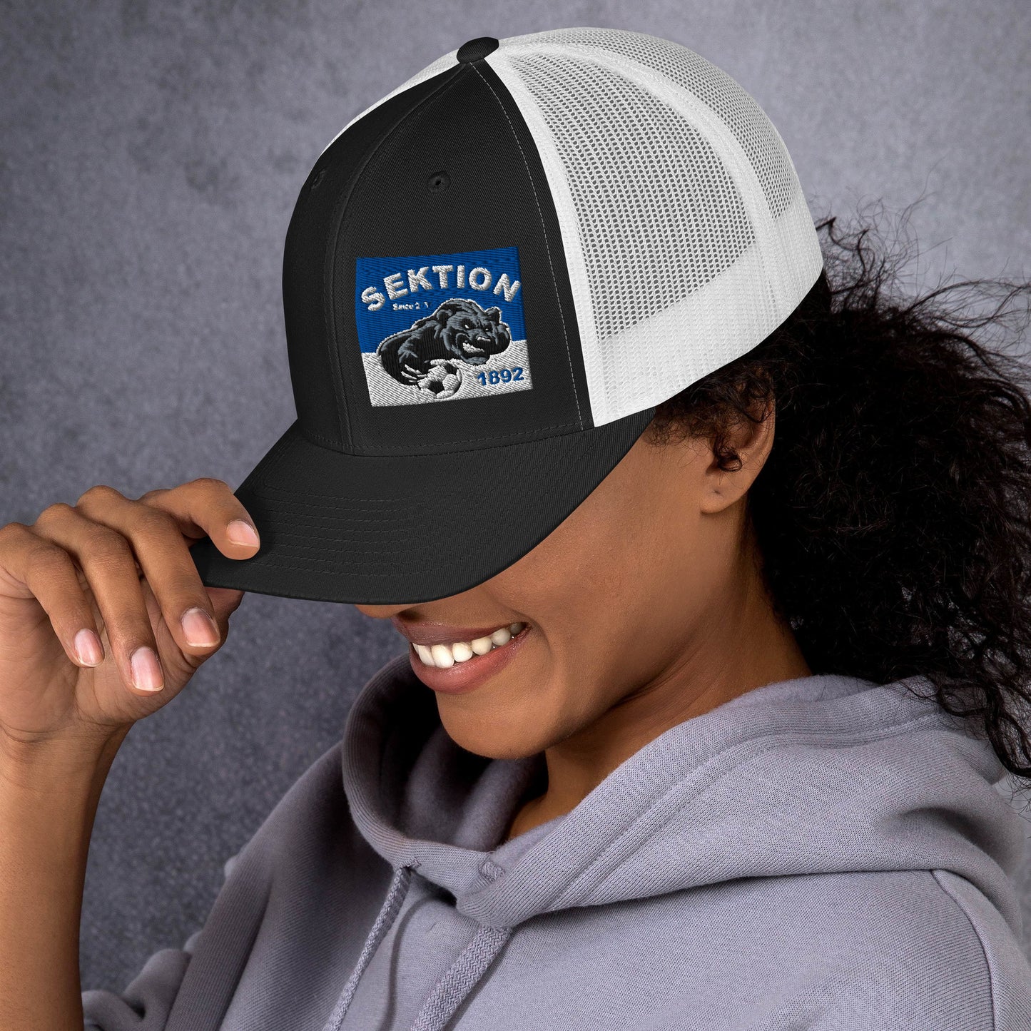 Retro Trucker-Cap von Sportswear Iron Monkey 23 in Schwarz und Weiß, zeigt das klassische Design mit Mesh-Back und gebrandetem Frontpanel.