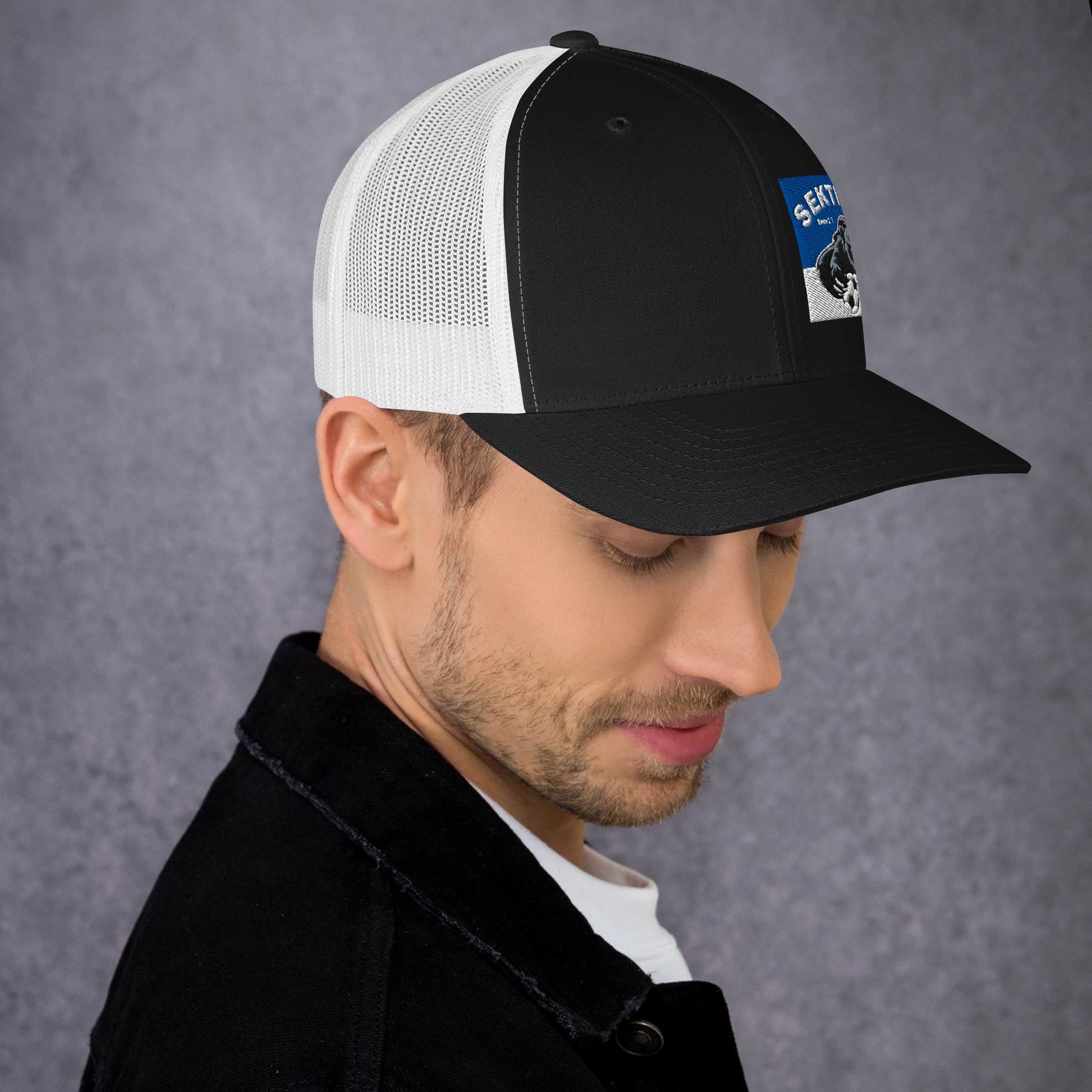 Retro Trucker-Cap von Sportswear Iron Monkey 23 in Schwarz-Weiß, zeigt die Vorderseite mit Mesh-Design und gesticktem Logo.