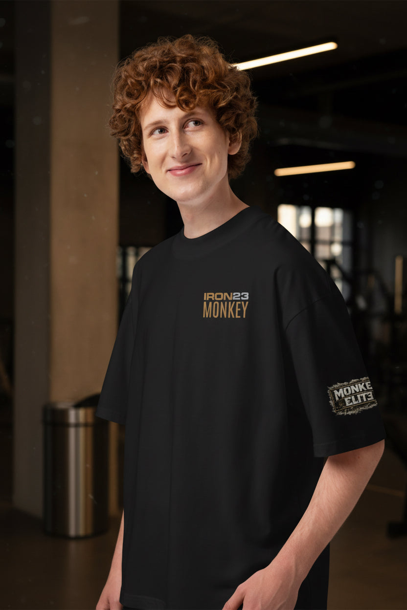 Unisex Bio-Oversized T-Shirt von Sportswear Iron Monkey 23 mit breitem Kragen, schwarzes, nachhaltiges Baumwoll-Shirt, links fotografiert